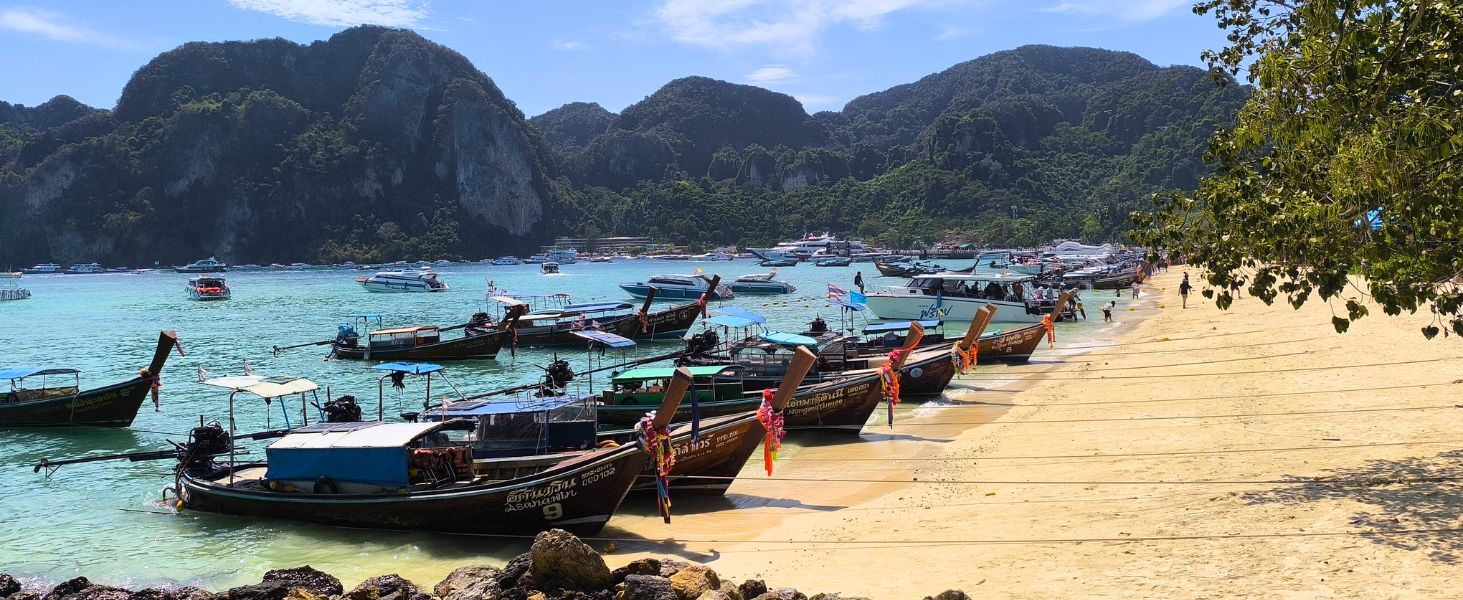 Tropischer Strand in Thailand mit türkisfarbenem Meer und Inselkulisse